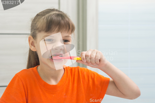 Image of A teenage girl cleans her front teeth