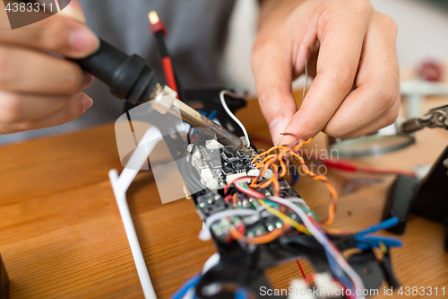 Image of Man welding parts on drone body