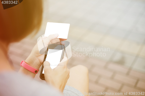 Image of Woman using phone and card for shopping