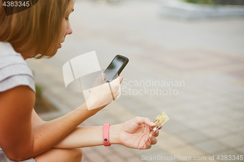 Image of Woman using phone and card for shopping