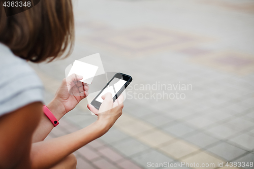 Image of Woman using phone and card for shopping