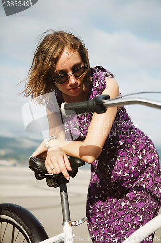 Image of Dreaming girl posing with bicycle