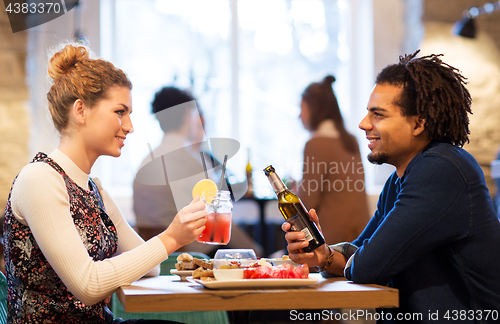 Image of happy couple with drinks at restaurant or bar