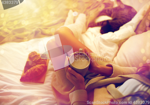 Image of close up of woman with cocoa cup in bed