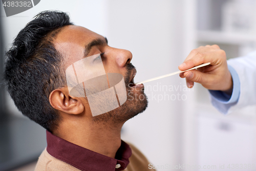 Image of doctor hand examining patient throat at clinic