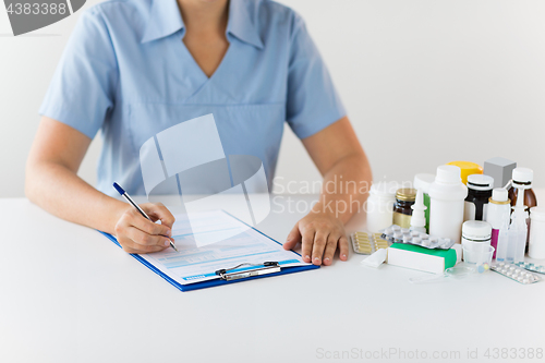 Image of doctor with medicines and clipboard at hospital