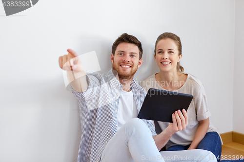 Image of happy couple with tablet pc computer at new home