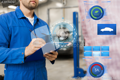 Image of auto mechanic with clipboard and man at car shop