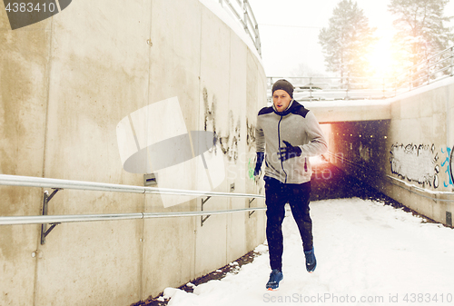 Image of man running out of subway tunnel in winter