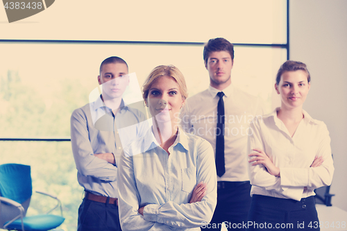 Image of business woman with her staff in background at office