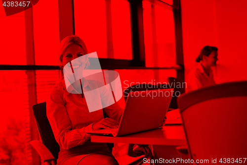 Image of business woman with her staff in background at office