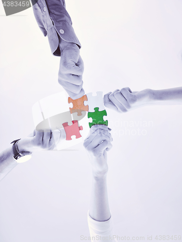 Image of Group of business people assembling jigsaw puzzle