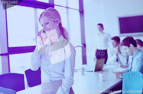 Image of business woman with her staff in background at office