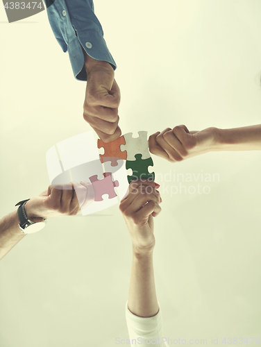 Image of Group of business people assembling jigsaw puzzle