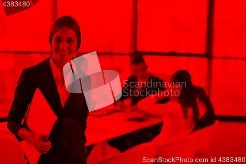 Image of business woman with her staff in background at office