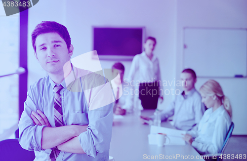 Image of business man  on a meeting in offce with colleagues in backgroun