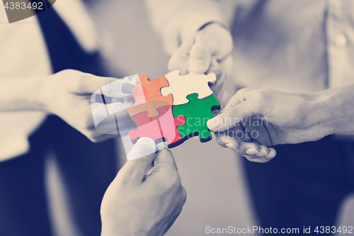 Image of Group of business people assembling jigsaw puzzle