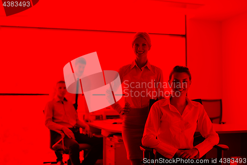 Image of business woman with her staff in background at office