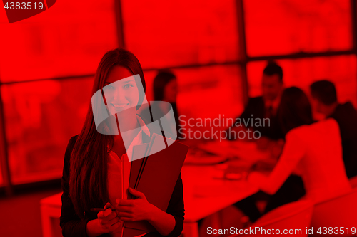 Image of business woman with her staff in background at office