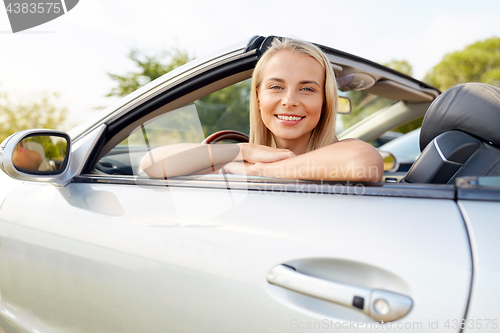 Image of happy young woman in convertible car