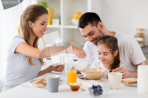 Image of happy family having breakfast at home