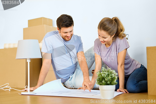 Image of couple with boxes and blueprint moving to new home