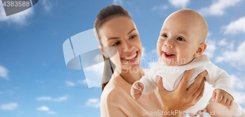 Image of happy mother playing with little baby boy over sky