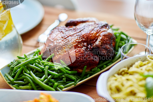 Image of roast chicken with garnish of green peas on table