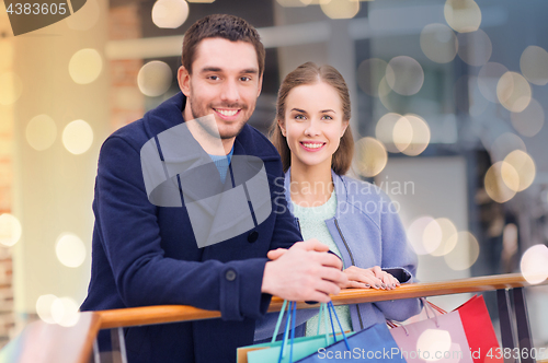 Image of happy young couple with shopping bags in mall