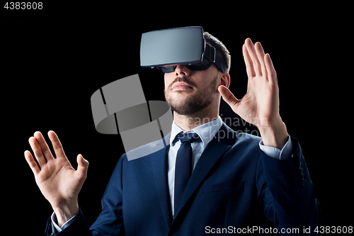 Image of businessman in virtual reality headset over black