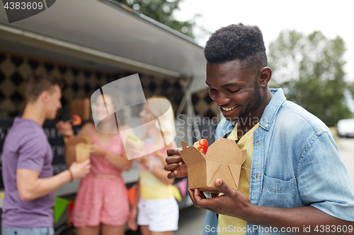 Image of happy man with wok and friends at food truck