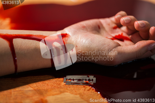 Image of dead woman hand in blood on floor at crime scene