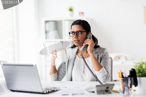 Image of businesswoman calling on phone at office