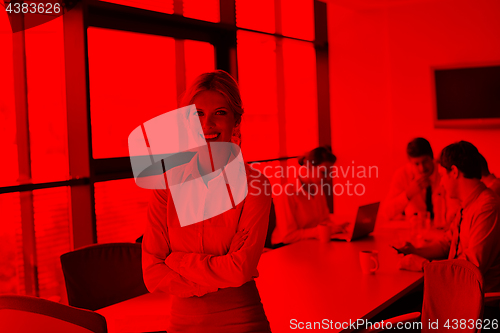 Image of business woman with her staff in background at office