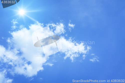 Image of bright blue sky with sun and clouds background