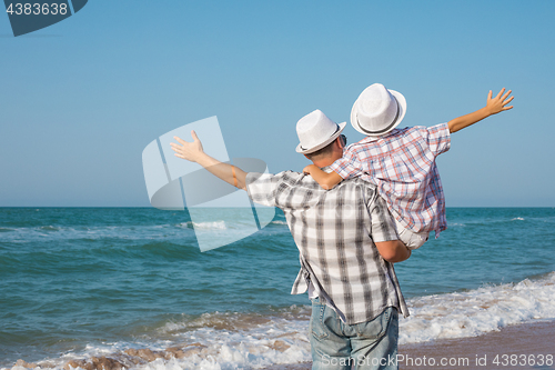 Image of Father and son playing on the beach at the day time.