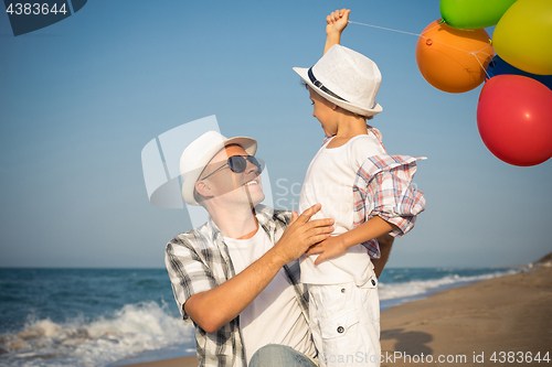 Image of Father and son playing on the beach at the day time.