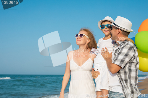 Image of Father mother and  son  playing on the beach at the day time.