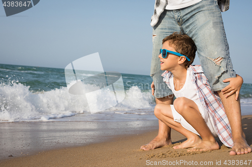 Image of Father and son playing on the beach at the day time.