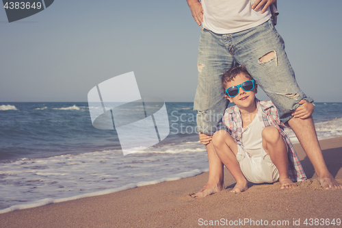 Image of Father and son playing on the beach at the day time.