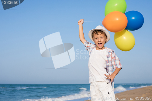 Image of One happy little boy playing on the beach at the day time. 