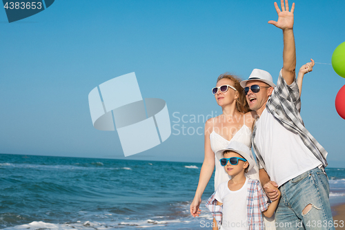 Image of Father mother and  son  playing on the beach at the day time.