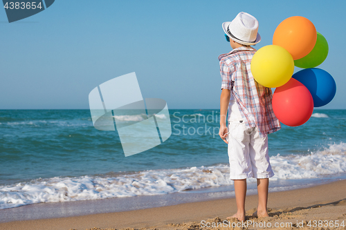 Image of One happy little boy playing on the beach at the day time.