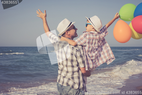 Image of Father and son playing on the beach at the day time.