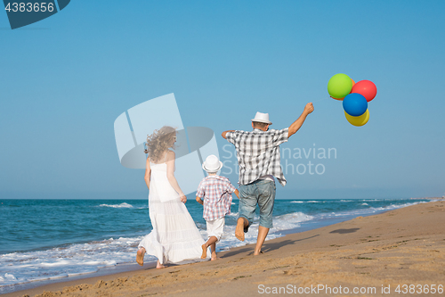 Image of Father mother and  son  playing on the beach at the day time.