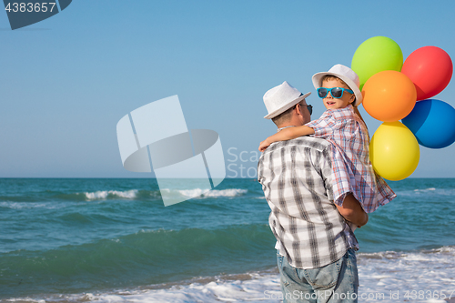 Image of Father and son playing on the beach at the day time.