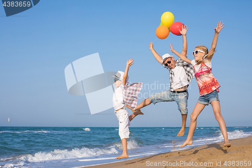 Image of Father and son and daughter playing on the beach at the day time