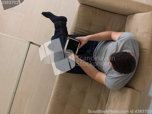 Image of man on sofa using tablet computer