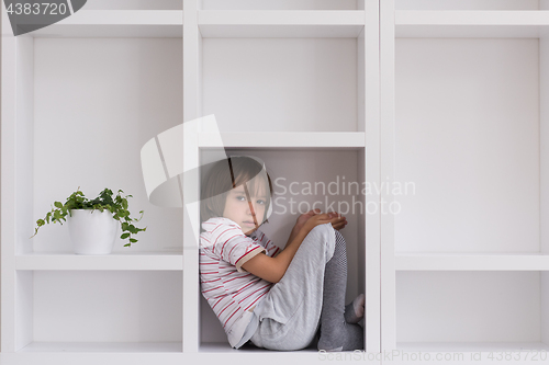 Image of young boy posing on a shelf