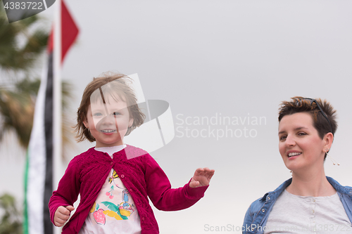 Image of mother and cute little girl on the promenade by the sea